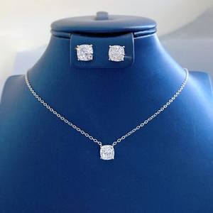 Macro shot of 1.5ct cushion-cut diamond necklace and earring set on a blue bust