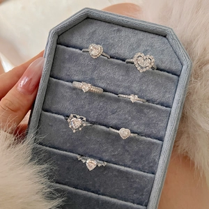 Detailed view of elegant S925 sterling silver heart rings set in a blue velvet jewelry box