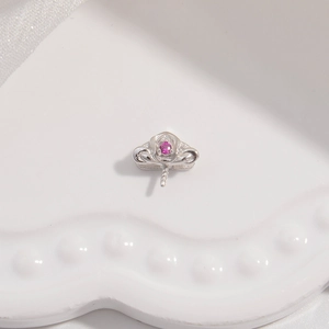 Macro shot of silver S925 floral pendant setting with pink gemstone on white tray