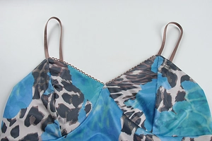 Makroansicht des V-Ausschnitts mit Spitzenbesatz und Satin-Stoff mit blauem Tiermuster