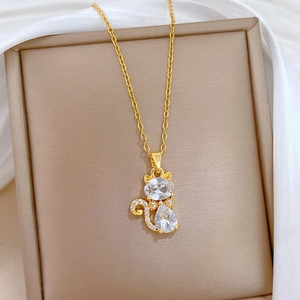 Vue détaillée du pendentif chat serti de cristaux sur un collier doré en acier au titane