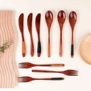 Macro shot of 9-piece wooden cutlery set with twine-wrapped handles on a rustic tray