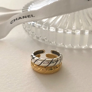 Detailed view of two quilted pattern open rings in silver and champagne gold finish