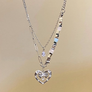 Close-up of multilayer silver necklace with heart pendant, water drop zircon and pearls