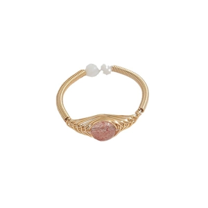 Handmade 14K gold wire wrapped ring featuring a round pink strawberry quartz stone