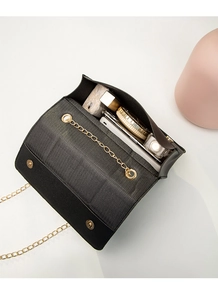 Top view of black crossbody bag showing internal storage for lipstick and phone