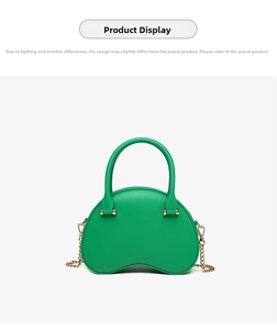Close-up of trendy emerald green pea-shaped handbag with elegant gold chain strap