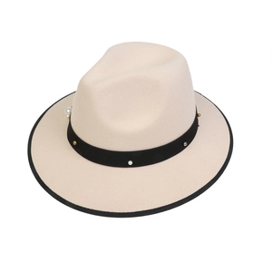 Detail of off-white felt fedora hat featuring black ribbon with pearls and metal studs