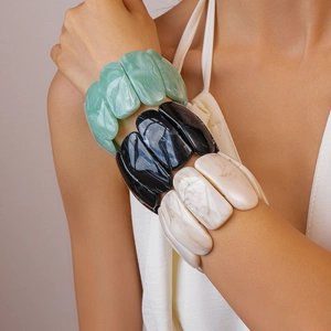 Close-up of marble-textured acrylic resin bangles in mint green, black and cream colors