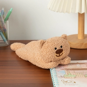 Detailed view of the soft brown plush bear pencil case on a cozy wooden desk