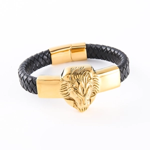 Macro shot of a black braided leather bracelet with a gold lion head and metal charms