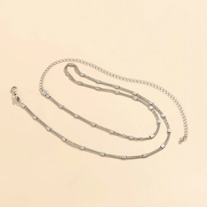 Detail of layered silver body chain with matte metal plates and adjustable lobster clasp