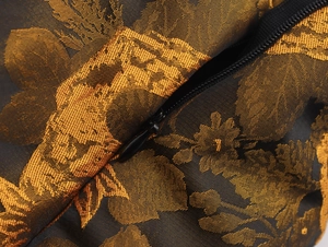 Dettaglio macro del tessuto jacquard floreale scuro con cerniera nera invisibile