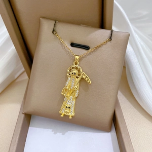 Detailed view of luxury gold reaper pendant with crystals on a beige jewelry box