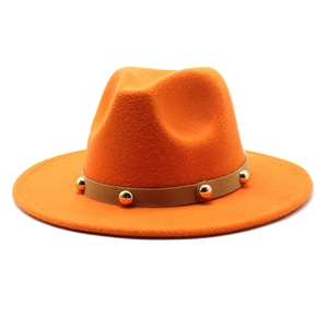 Detailed macro of orange felt jazz hat with brown leather band and gold metal rivets