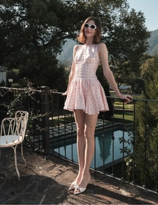 Close-up of pink and white checkered mini dress with buttons and a slim-fit waist design