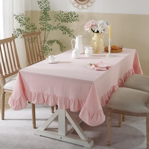 Detail of pink washed cotton tablecloth featuring elegant pleated ruffle edges and soft texture
