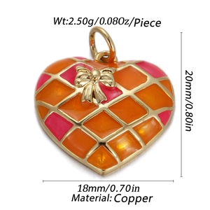 Detail of heart pendant with orange enamel pattern and golden bow including dimensions