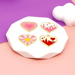 Pink heart-shaped alloy pendants for DIY jewelry making on white geometric pedestals