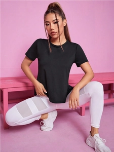 T-shirt de yoga noir ample pour femme avec dos en mesh respirant sur fond rose vif