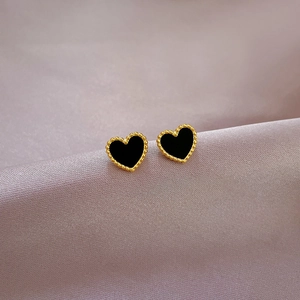 Macro shot of titanium steel heart studs with gold beaded edges and black inlay