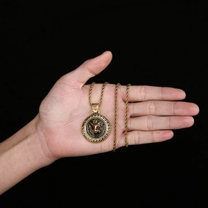 Pendentif tête de lion rétro doré avec chaîne torsadée présenté sur une main