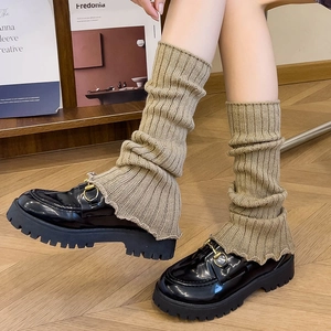 Khaki knitted leg warmers styled with black platform loafers for fall season