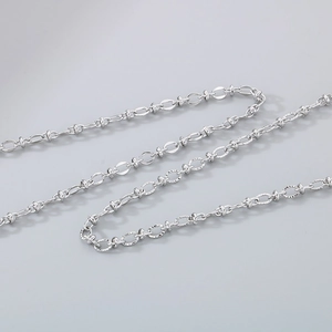 Close-up of polished silver metal chain necklace links with subtle glossy texture