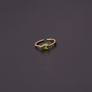 Detail of beaded gold band with a pear-cut green zircon stone in a macro view