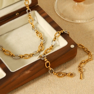 Macro shot of two-tone oval link chain showing S.STEEL stamp on stainless steel clasp