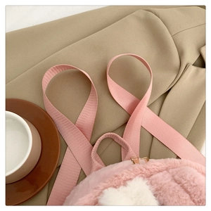 Close-up of pink and white plush rabbit ear backpack with durable nylon shoulder straps