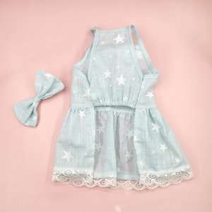 Close-up of blue floral dog dress with star patterns and matching bow accessory