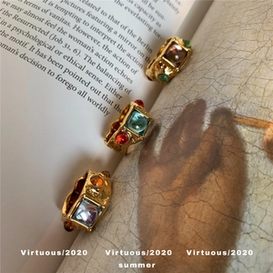 Detail of vintage gold-plated rings with hammered texture and colorful gemstones