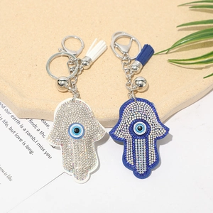 Close-up of Hamsa Hand keychains with rhinestones, evil eye motif and tassel charms