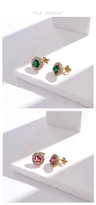 Vue détaillée de boucles d'oreilles dorées géométriques avec pierres vertes et roses