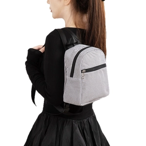 Mini striped seersucker backpack for women showing side-view on model with adjustable straps