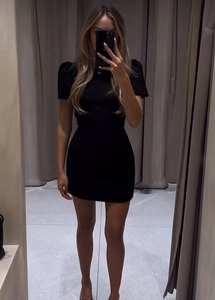 Detailed full-body mirror selfie showing the slim-fit black puff sleeve mini dress on a model