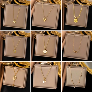 Collection of nine gold titanium steel necklaces featuring heart and clover pendants