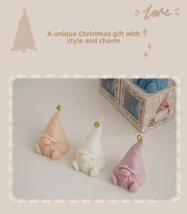 Detailed view of gnome-shaped scented candles with golden bells and gift packaging