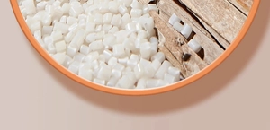 Gros plan de granulés de résine plastique blanche sur une surface en bois lisse