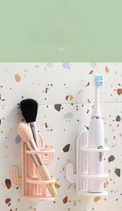 Detail of pink and white cactus-shaped wall-mounted toothbrush holders for bathroom storage