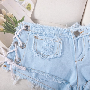 Dettaglio degli shorts in denim azzurro con lacci laterali e bordi sfrangiati trendy