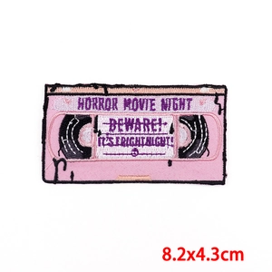 Macro shot of 8.2x4.3cm pink VHS horror movie night embroidered patch detail
