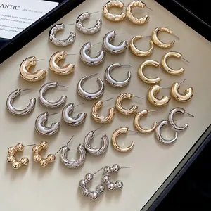 Minimalist C-shaped hoop earrings set with gold and silver polished textures