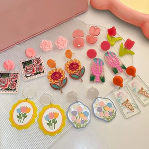Boucles d'oreilles colorées en acrylique avec tulipes et roses sur plateau en verre