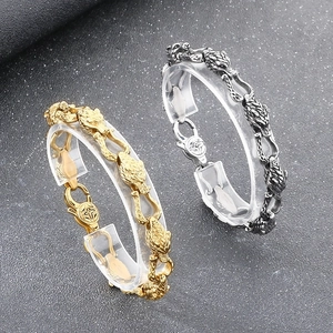 Detailed close-up of retro wolf head links on stainless steel bracelets in gold and silver