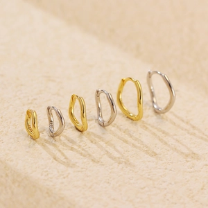 Close-up of S925 sterling silver stamp on irregular wavy golden hoop earrings set