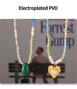 Detail of PVD plated vintage necklaces with green malachite heart and pearl pendant
