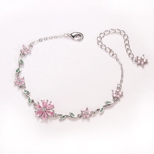 Detail of silver cherry blossom bracelet with pink zircons and green crystal leaves