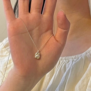 Elegante goldene Erbsenhalskette mit hohlem Käfiganhänger und weißer Perle an Silberkette